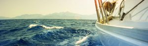 Charters sailing boat tours on open sea with mountain views